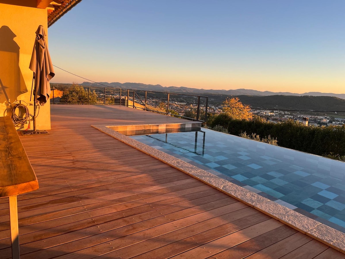 Terrasse de piscine à débordement au coucher du soleil, image d'une villa dont la gestion prend du temps